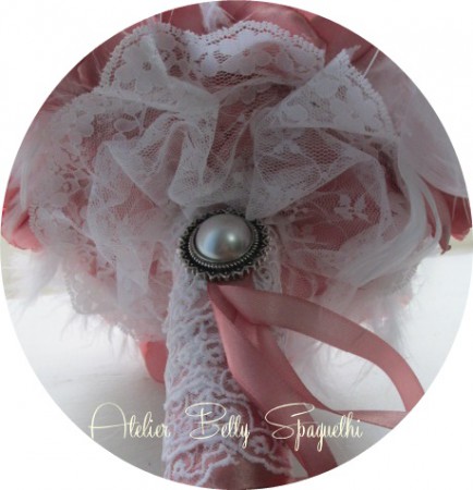 Bouquet Shabby Chic com rosas e peónias em cetim tom rosa velho, com apliques de bijuteria e plumas brancas. Pé forrado a cetim e renda branca com aplique prateado com pérola